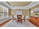 Elegant dining room with a chandelier, tray ceiling, and a large window at 3870 Cabalzar St, Cumming, GA 30040