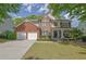 Charming two-story home with brick and stone accents, a manicured lawn, and a two-car garage at 3870 Cabalzar St, Cumming, GA 30040