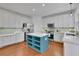 Updated kitchen with white cabinetry, a blue island, and stainless steel appliances at 3870 Cabalzar St, Cumming, GA 30040
