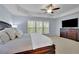 Comfortable main bedroom showcasing a tray ceiling, large windows, and a dresser with a TV at 3870 Cabalzar St, Cumming, GA 30040