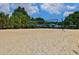 Community sand volleyball court with net, benches, and trees in the background at 3870 Cabalzar St, Cumming, GA 30040