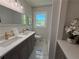 Bathroom featuring double sink vanity, marble tile floor, and picture window at 563 Hillandale Circle Sw, Marietta, GA 30064