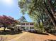 Two-story house with a well-manicured lawn and surrounded by mature trees on a sunny day at 563 Hillandale Circle Sw, Marietta, GA 30064