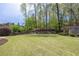 Spacious backyard featuring a lush lawn, mature trees, and a wooden fence at 648 Gold Valley Pass, Canton, GA 30114