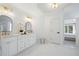 Bright bathroom with white marble floors, double vanity, gold fixtures, and a view into the bedroom at 648 Gold Valley Pass, Canton, GA 30114