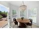 Breakfast nook has a modern chandelier, table with four chairs, and a view of the outdoor deck at 648 Gold Valley Pass, Canton, GA 30114