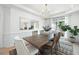 Elegant dining room with a wooden table, chandelier, and large mirror reflecting natural light at 648 Gold Valley Pass, Canton, GA 30114