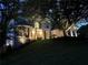 An elegant home nestled among mature trees with landscape lighting at 648 Gold Valley Pass, Canton, GA 30114