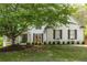 Charming white brick home with lush front yard landscaping, dark shutters and a covered front porch at 648 Gold Valley Pass, Canton, GA 30114