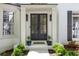 Close-up of the home's entrance, with double doors, manicured bushes, and a white brick facade at 648 Gold Valley Pass, Canton, GA 30114