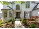 Elegant white brick home featuring a covered entrance, double doors, and manicured landscaping at 648 Gold Valley Pass, Canton, GA 30114