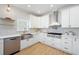 Kitchen features stainless steel dishwasher, farm sink, designer backsplash and countertops and hardwood flooring at 648 Gold Valley Pass, Canton, GA 30114