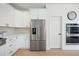 Kitchen features stainless steel appliances, white cabinetry, double ovens, and a view of hardwood flooring at 648 Gold Valley Pass, Canton, GA 30114