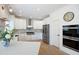 Bright kitchen features stainless steel appliances, an island, herringbone backsplash, and hardwood floors at 648 Gold Valley Pass, Canton, GA 30114