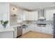 Beautiful kitchen with stainless appliances, white cabinetry, designer backsplash, and hardwood flooring at 648 Gold Valley Pass, Canton, GA 30114
