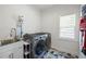 Laundry room has a modern washer and dryer, geometric tile floor, utility sink and natural light at 648 Gold Valley Pass, Canton, GA 30114
