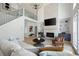 Bright living room featuring a stone fireplace, high ceilings, and a staircase leading to the second floor at 648 Gold Valley Pass, Canton, GA 30114