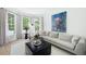 Bright living room featuring hardwood floors, large windows, and a comfortable L-shaped sofa at 648 Gold Valley Pass, Canton, GA 30114