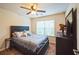 Cozy bedroom featuring a ceiling fan, window, and comfortable bed with decorative pillows and a dark wood dresser at 7779 Haynes Park Cir, Lithonia, GA 30038