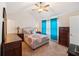 Comfortable bedroom with a ceiling fan, carpet, and natural light from the window with bright blue curtains at 7779 Haynes Park Cir, Lithonia, GA 30038