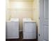 Practical laundry room with a washer, dryer, and overhead shelving at 7779 Haynes Park Cir, Lithonia, GA 30038
