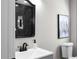 Bathroom featuring an undermount sink, a black faucet, a vanity mirror and a wall-mounted toilet at 1515 Jonesboro Rd, Atlanta, GA 30315