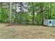 Expansive backyard featuring lush greenery, water view, and a storage shed at 226 Sandra Nw Dr, Lilburn, GA 30047