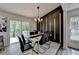 Dining room showcases a modern black accent wall, contemporary chandelier, and large sliding glass door at 226 Sandra Nw Dr, Lilburn, GA 30047