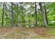 Tranquil lake view from the backyard, bordered by mature trees and greenery at 226 Sandra Nw Dr, Lilburn, GA 30047