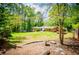 Expansive backyard with mature trees, carport, and lush lawn, perfect for outdoor enjoyment at 3224 Laura Way, Winston, GA 30187