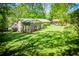 Spacious backyard with lush greenery, mature trees, and a view of the home's exterior at 3224 Laura Way, Winston, GA 30187