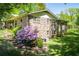 Brick house with mature trees and a lush landscaped yard with stone steps leading to the backyard at 3224 Laura Way, Winston, GA 30187