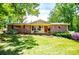 Charming brick home featuring a cozy front porch, mature trees, and a well-manicured lawn at 3224 Laura Way, Winston, GA 30187