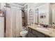 Neutral bathroom with granite counter tops, tiled shower with dark fixtures, and an arched window decoration at 6414 Blue Water Dr, Buford, GA 30518