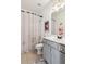 Bright bathroom featuring a shower with curtain, a vanity with storage, and tiled floor at 6414 Blue Water Dr, Buford, GA 30518