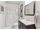 Modern bathroom with a glass-enclosed shower, dark vanity, and elegant tile backsplash at 6414 Blue Water Dr, Buford, GA 30518