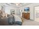 Relaxing bedroom with tray ceiling and a TV; access to on-suite bathroom and hall at 6414 Blue Water Dr, Buford, GA 30518