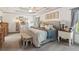 Spacious bedroom with a decorative bench, tray ceilings, and a large, upholstered headboard at 6414 Blue Water Dr, Buford, GA 30518