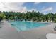 Community pool with a large slide, lounge chairs, umbrellas, and mature trees offering shade at 6414 Blue Water Dr, Buford, GA 30518