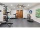 Well-equipped exercise room with a treadmill, weightlifting equipment, and a ceiling fan for comfort at 6414 Blue Water Dr, Buford, GA 30518