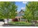 Charming brick home with manicured lawn, mature trees, and inviting front porch with covered entrance at 6414 Blue Water Dr, Buford, GA 30518