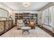 Cozy living room with custom bookshelves, chairs, and neutral rug at 6414 Blue Water Dr, Buford, GA 30518