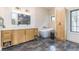 Modern bathroom with a soaking tub, double vanity, stylish mirror, and black tiled floors at 3840 Wieuca Ne Ter, Atlanta, GA 30342