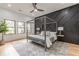 Modern bedroom with a dark accent wall, neutral-colored bedding, hardwood floors, and natural light at 3840 Wieuca Ne Ter, Atlanta, GA 30342