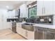 Gourmet kitchen featuring stainless steel appliances, white cabinets, black subway tile, and a farmhouse sink at 3840 Wieuca Ne Ter, Atlanta, GA 30342