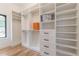 Spacious walk-in closet with custom shelving and drawers for optimal organization and window for natural light at 3840 Wieuca Ne Ter, Atlanta, GA 30342