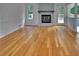 Open living room featuring hardwood floors, a stone fireplace, and natural light from large windows at 4270 Mountain Glen Trce, Snellville, GA 30039