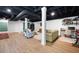 Spacious finished basement area with light wood flooring and painted black ceiling at 6005 Cherecobb Ln, Woodstock, GA 30188