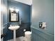 Charming half-bathroom with pedestal sink, wainscoting, and decorative mirror at 6005 Cherecobb Ln, Woodstock, GA 30188