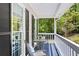 Inviting covered front porch with seating area to relax and enjoy the scenic nature views at 6005 Cherecobb Ln, Woodstock, GA 30188